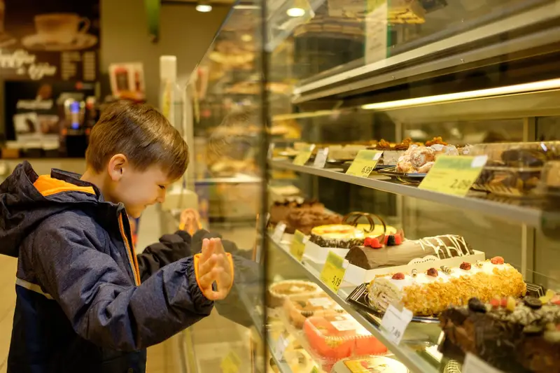 cake displays at whole foods - kids looking into display smiling. 